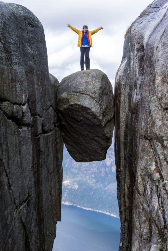 A participant standing on top of a boulder on a dream trip to Norway.
